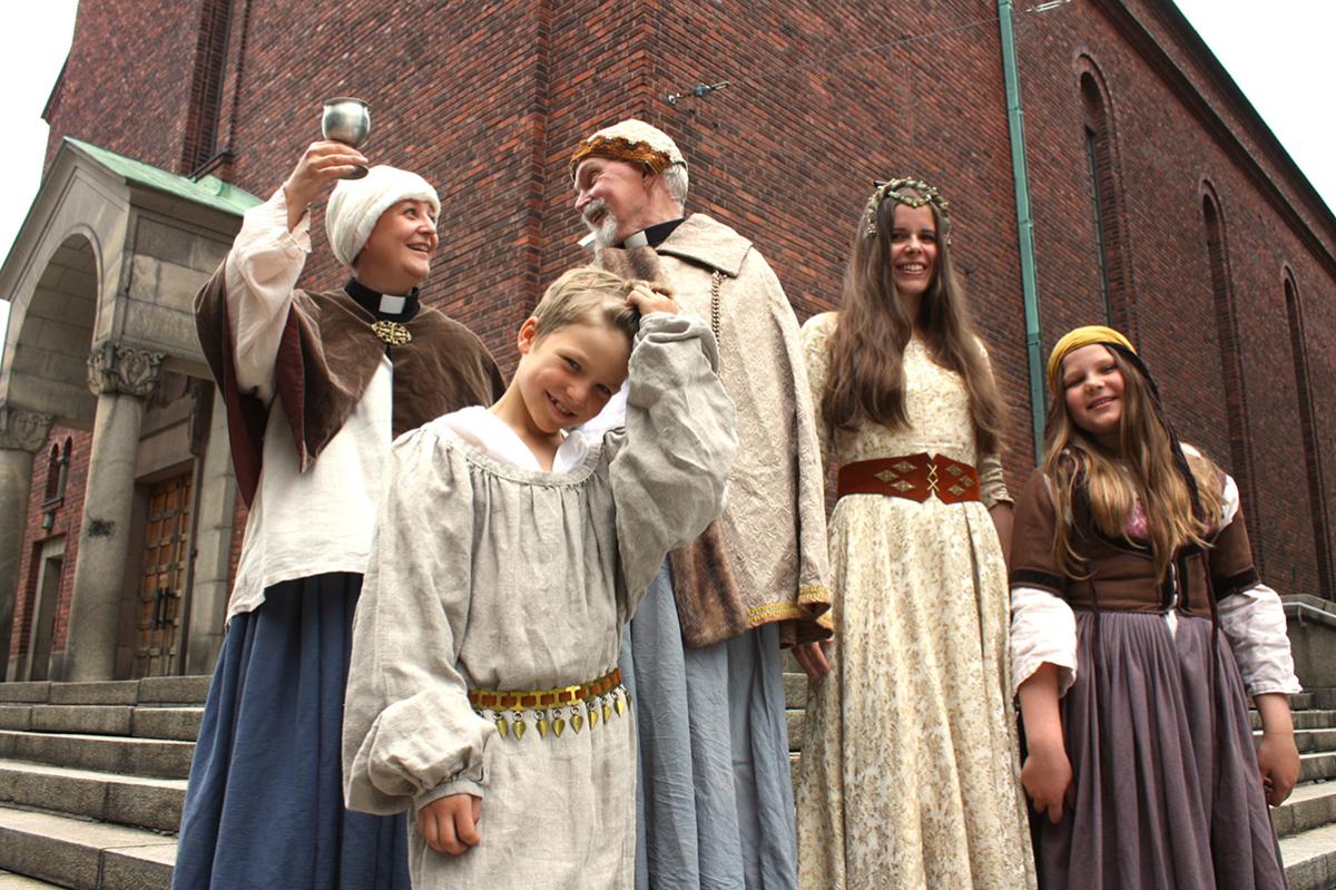 Pappi Tuuli Aitolehti (vasemmalla), eläkkeellä oleva rovasti Heikki Laukkanen, suntio Heidi From ja keppiradasta vastaavat lapset ovat mukana Paavalinkirkon keskiaikatapahtumassa.